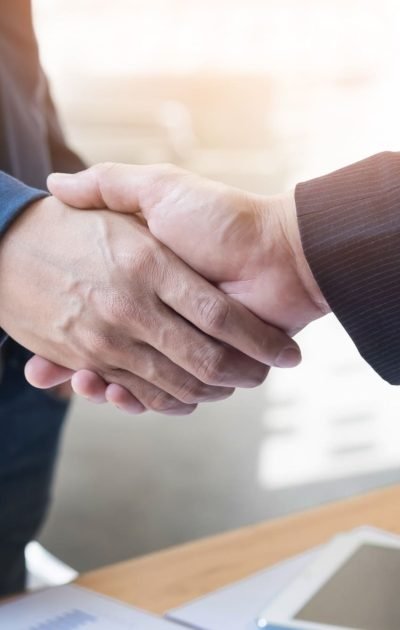 dos-hombres-de-negocios-confia-en-estrechar-la-mano-durante-una-reunion-en-la-oficina-el-exito-el-trato-el-saludo-y-el-concepto-de-socio (1)